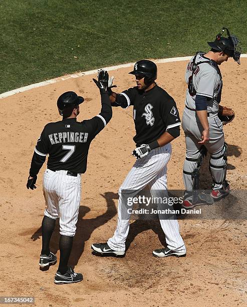 Alex Rios of the Chicago White Sox is congratulated by Jeff Keppinger after hitting a two-run home run in the 5th inning in front of Lou Marson of...