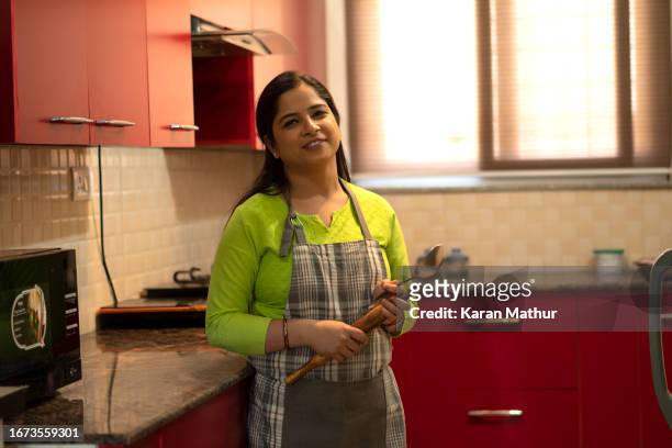 young housewife working in kitchen at home - stereotypical homemaker stock pictures, royalty-free photos & images