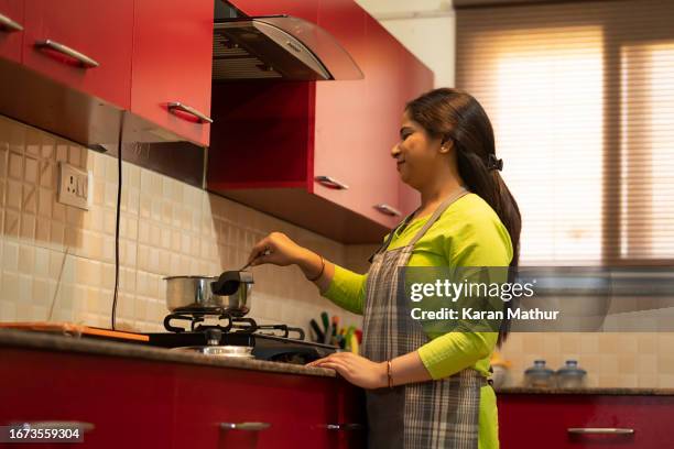 young housewife working in kitchen at home - housekeeping staff stock pictures, royalty-free photos & images