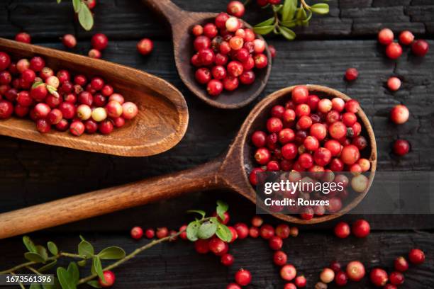 cranberries in a bowl on wooden background. - cranberry stock pictures, royalty-free photos & images