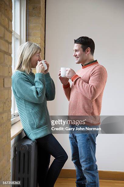 man and woman drinking coffee, standing - norman window fotografías e imágenes de stock