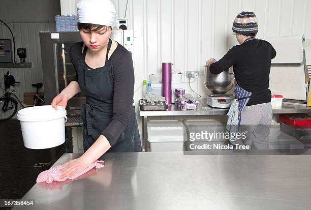 two bakers working in kitchen together - arbeitsplatte stock-fotos und bilder