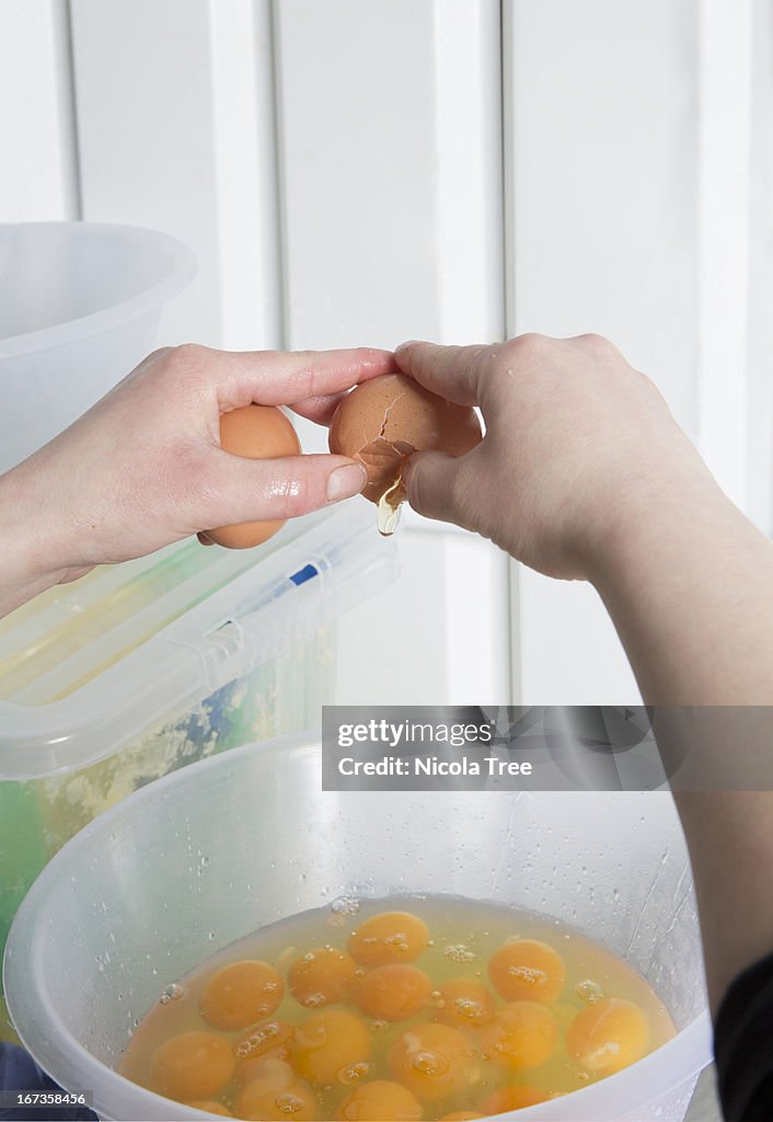 Baker cracking eggs into a bowl