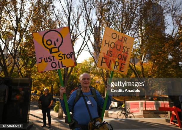 An activist holds a placard during the 'Rally for Climate Sanity' at the Calgary's Town Hall in opposition to the 24th World Petroleum Congress...