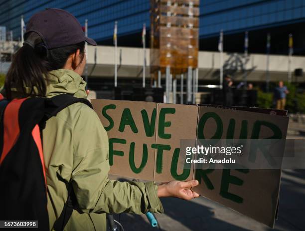 An activist holds a placard during the 'Rally for Climate Sanity' at the Calgary's Town Hall in opposition to the 24th World Petroleum Congress...