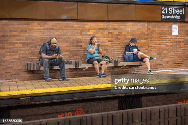 three people sitting on a bench - color enhanced stock pictures, royalty-free photos & images