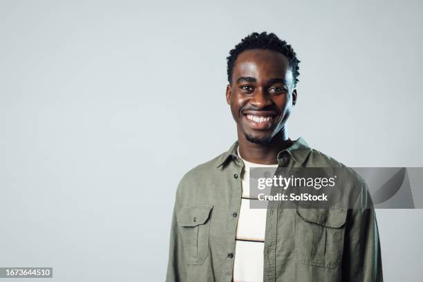 giovane maschio che posa su priorità bassa grigia - foto ritratto ufficiale foto e immagini stock