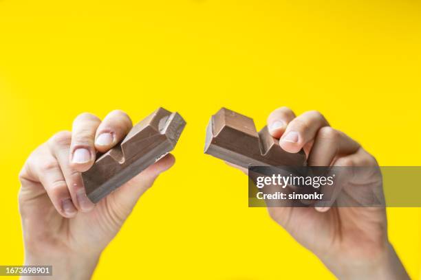 human hands breaking chocolate - chocolate bar stock pictures, royalty-free photos & images