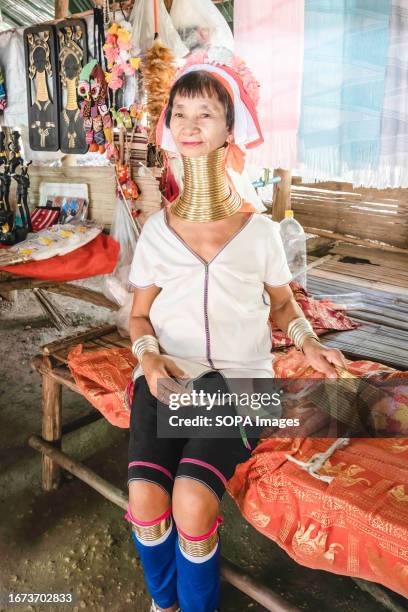 An elderly Padaung long-neck tribe woman is seen sitting at her handicraft booth at the Baan Tong Luang village in Mae Rim. The Padaung tribe is a...