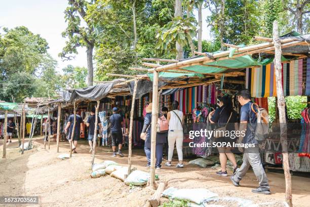 Group of tourists are seen walking inside the Baan Tong Luang village in Mae Rim. The Padaung tribe is a subset of the Karenni, which in turn is a...