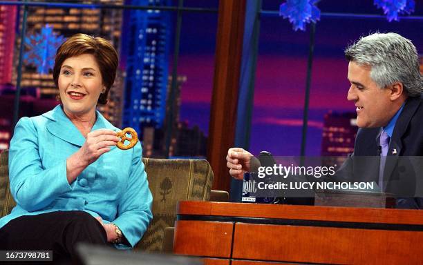 First Lady Laura Bush shows host Jay Leno a pretzel similar to the one her husband President George W. Bush choked on, at a taping of The Tonight...