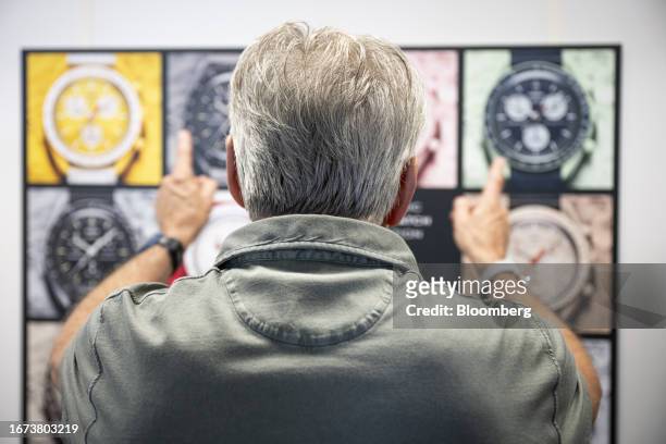 Nick Hayek, chief executive officer of Swatch Group AG, points to a poster showing Swatch x Omega MoonSwatch watches at the Swatch ETA factory in...
