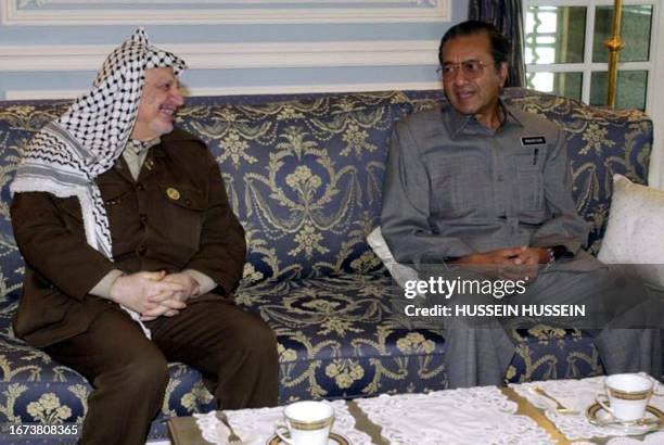 Malaysian Prime Minister Mahathir Mohamad speaks with Palestinian leader Yasser Arafat during a meeting in the capital Kuala Lumpur 25 August 2001....