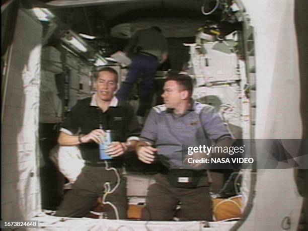 Space shuttle Discovery Commander James Wetherbee and Pilot James Kelly conduct an on orbit interview from the Italian-built Leonardo multi-purpose...