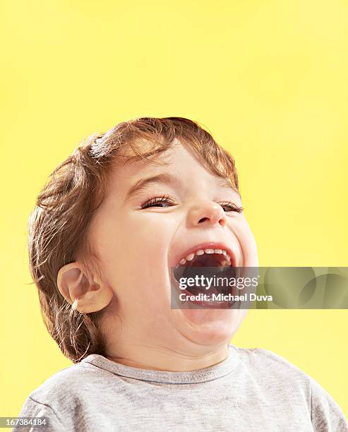 studio shot of a child on a yellow background - michael virtue stock pictures, royalty-free photos & images