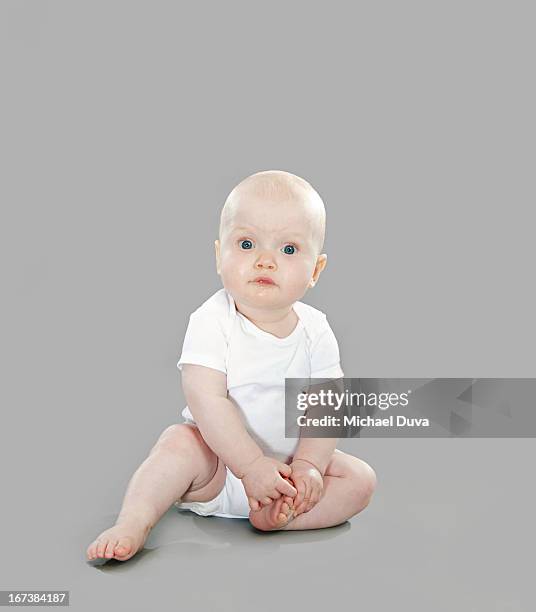 studio shot of a baby on gray background - michael virtue stock pictures, royalty-free photos & images
