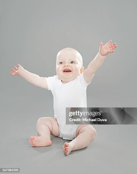 studio shot of a happy baby on gray background - michael virtue stock pictures, royalty-free photos & images