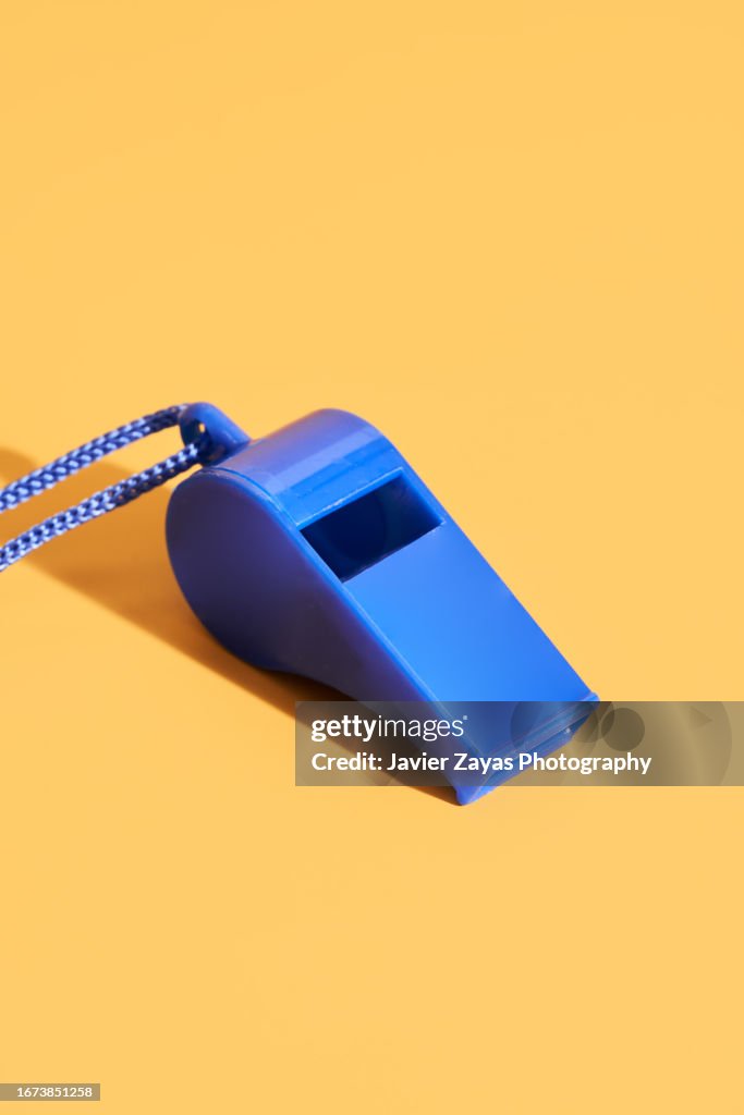 Blue Plastic Whistle On A Yellow Background