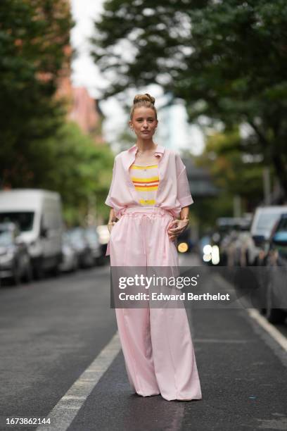 Victoria Magrath wears a pastel / pale pink shirt, a yellow and red striped top, pastel / pale pink flare / palazzo pants, outside Adeam, during New...