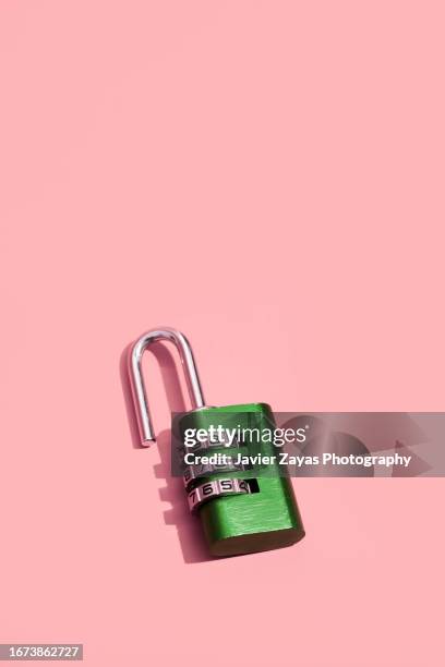 green padlock with numerical combination on pink background - password strength stock pictures, royalty-free photos & images