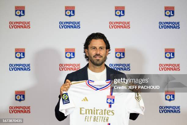 Lyon's Italian new head coach Fabio Grosso poses with a team jersey at the end of a press conference in the Decines-Charpieu Groupama Stadium in...