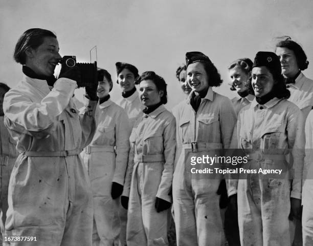 Member of the National Women's Air Reserve takes a photograph of her fellow recruits at the Maylands Aerodrome, Romford, Essex, 6th May 1939.