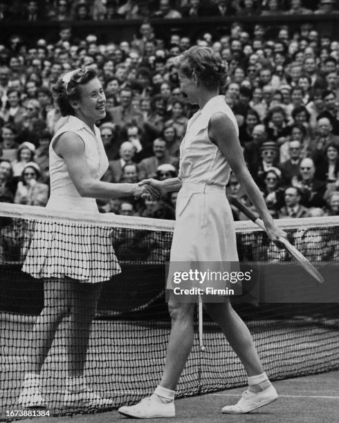 American tennis players Maureen Connolly and Louise Brough shake hands over the net after Connolly wins the Women's Singles Final match at the...