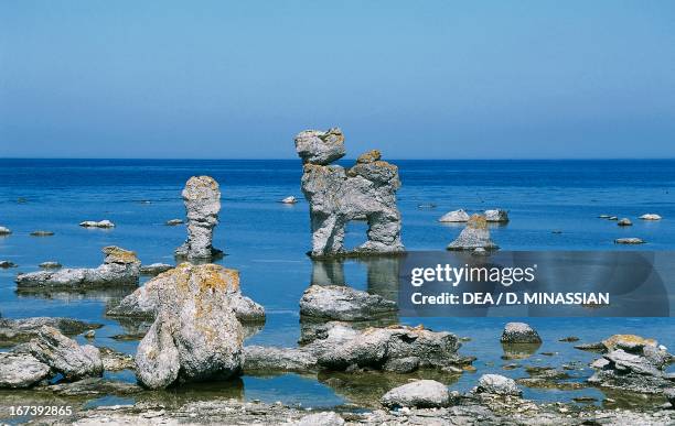 Ice Age stone monoliths known as rauks eroded into unusual shapes by water, Langhammar peninsula, Faro Island, Sweden.