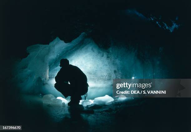 Caver in an old mine flooded by ice, Park Mont Avic Park, Champdepraz Valley, Valle d'Aosta, Italy.