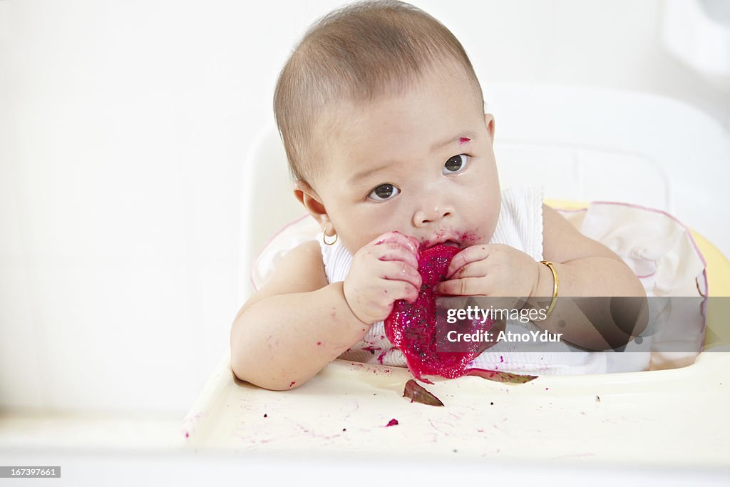Baby eating dragon fruit
