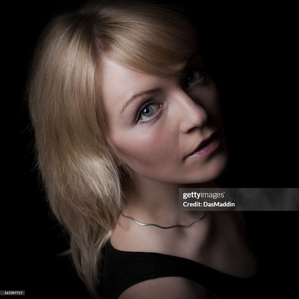 Lowkey portrait of a beautiful young girl looking into camera