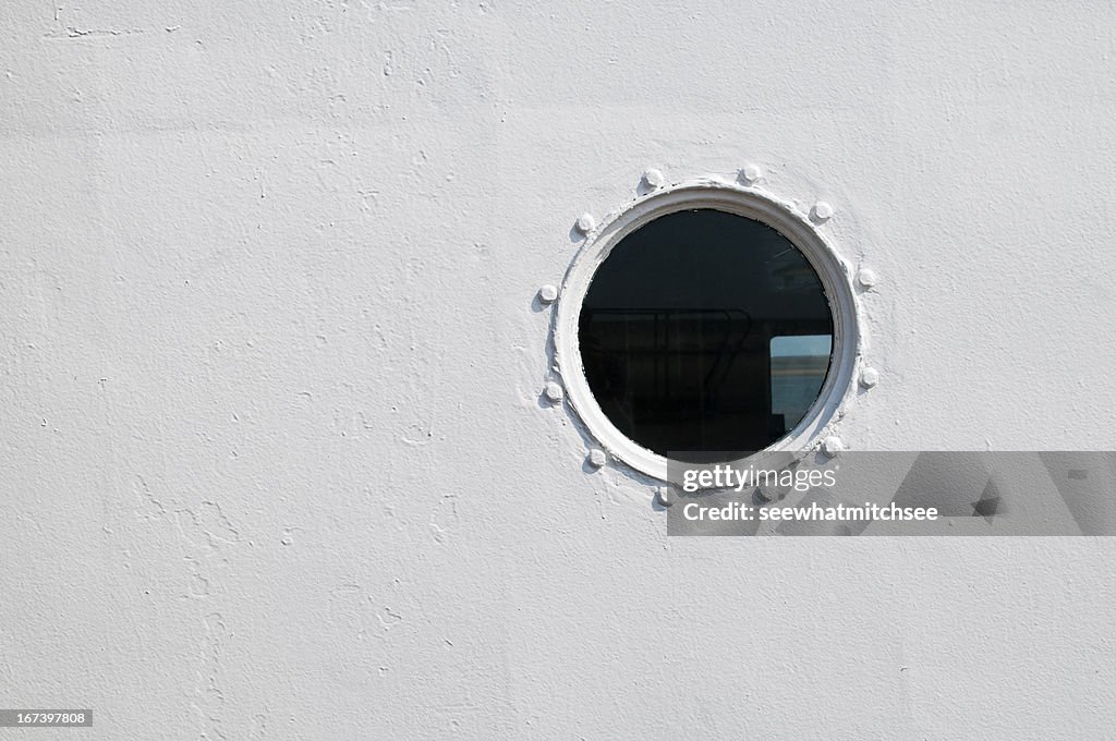 Painted brass porthole on the side of a ship