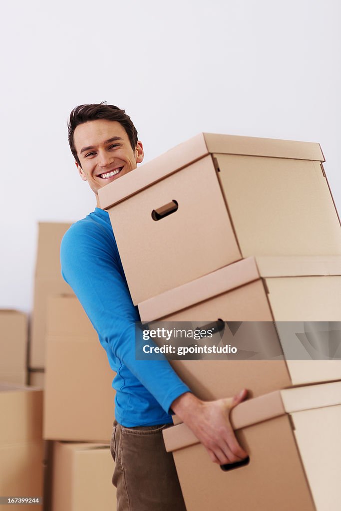 Hombre atractivo llevando montón de cajas