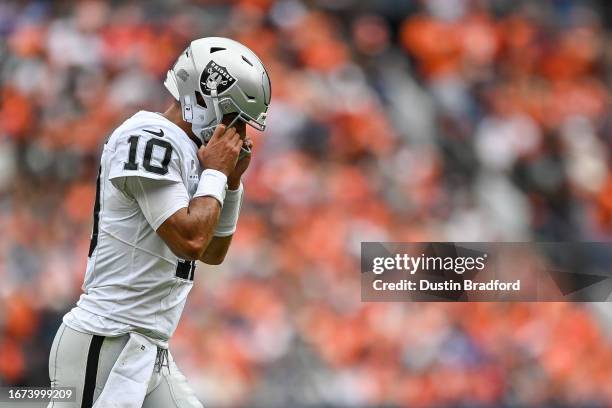 Jimmy Garoppolo of the Las Vegas Raiders puts his helmet on as he returns to the field after being checked for concussion symptoms in the first...