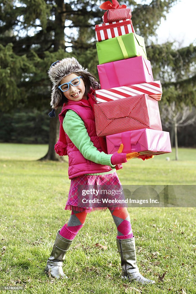 Heureuse jeune fille avec une pile de cadeaux