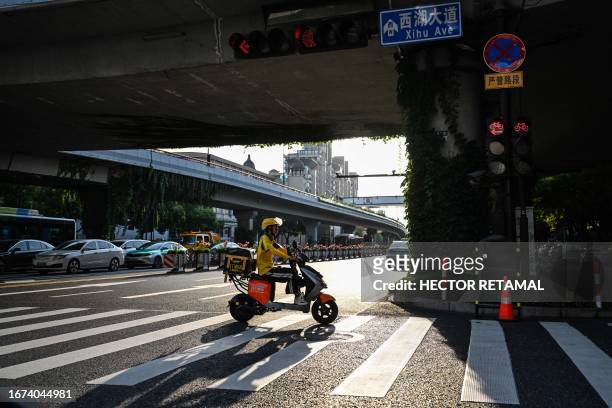 Man rides a scooter in Hangzhou, China's eastern Zhejiang province on September 18 ahead of the 19th Asian Games to be held in the city from...