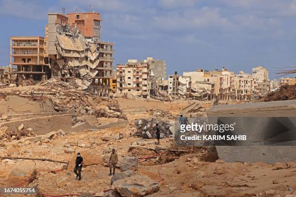 Rescue teams assist in relief work in Libya's eastern city of Derna September 18, 2023 following deadly flash floods. A week after a tsunami-sized...
