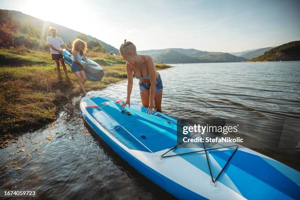 freunde auf den see - windsurfbrett stock-fotos und bilder