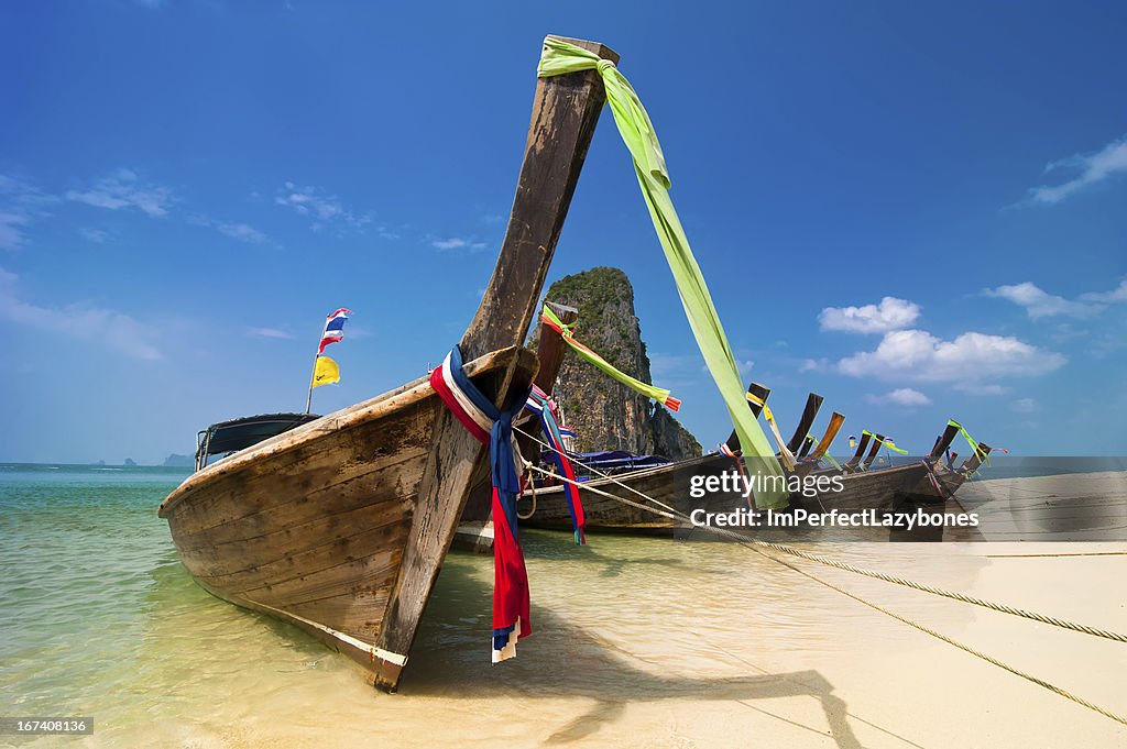 Tropical beach landscape. Thai long tail boats at ocean coast