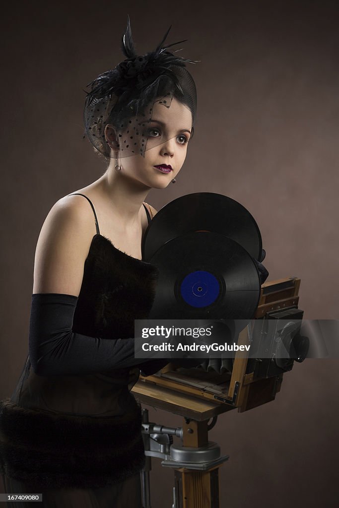 Young woman in retro style with vinyl plate