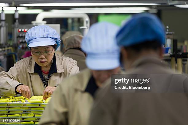 Jangup System Co. Employees inspect mascara containers on the production line for manufacturing cosmetics containers at the company's factory in...