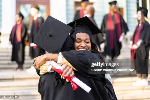 two female graduates embracing each other - accomplishment stock pictures, royalty-free photos & images