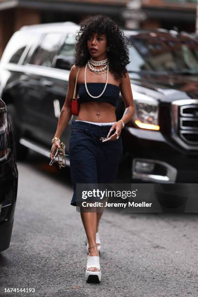 Tommy Hilfiger Fashion Brunch guest was seen wearing white plateau shoes, matching blue trousers and a blue bra, a red bag, long finger nails and...