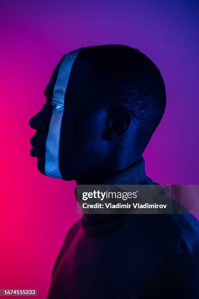 side profile of man with vertical stripe of light down his face - man face down stock pictures, royalty-free photos & images