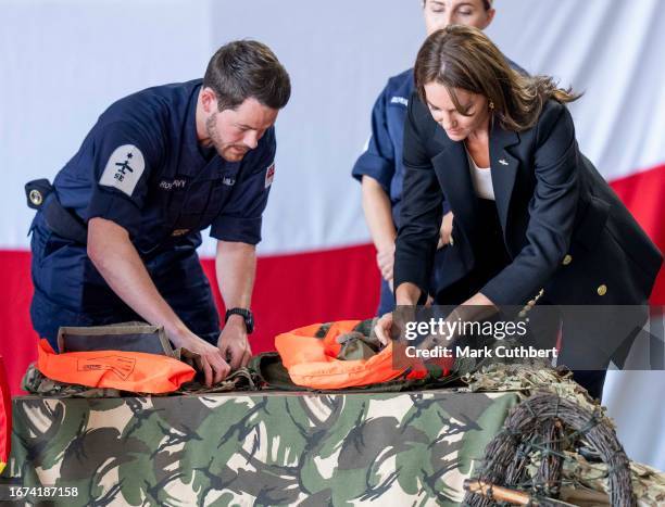 Catherine, Princess Of Wales packs a life vest before setting it off during her visit to Royal Naval Air Station Yeovilton on September 18, 2023 in...