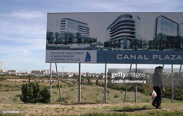 Pedestrian passes an advertisement for property at Canal Plaza at the Century City residential and entertainment property complex in Cape Town, South...
