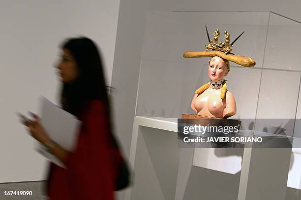 Woman walks past a sculpture entitled "Retrospective Bust of a Woman" by Spanish surrealist artist Salvador Dali during the exhibition "Dali. All of...