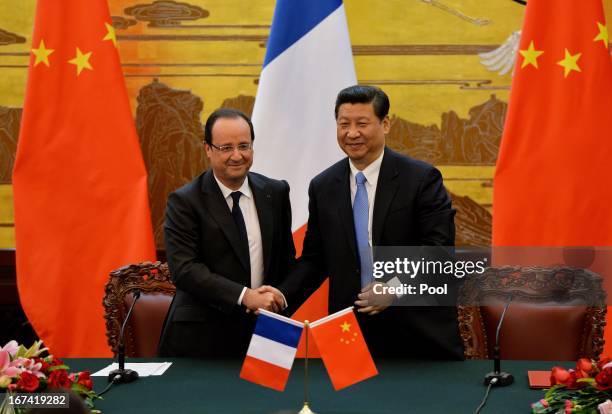 French President Francois Hollande and Chinese President Xi Jinping shake hands during a signing ceremony at the Great Hall of the People on April...