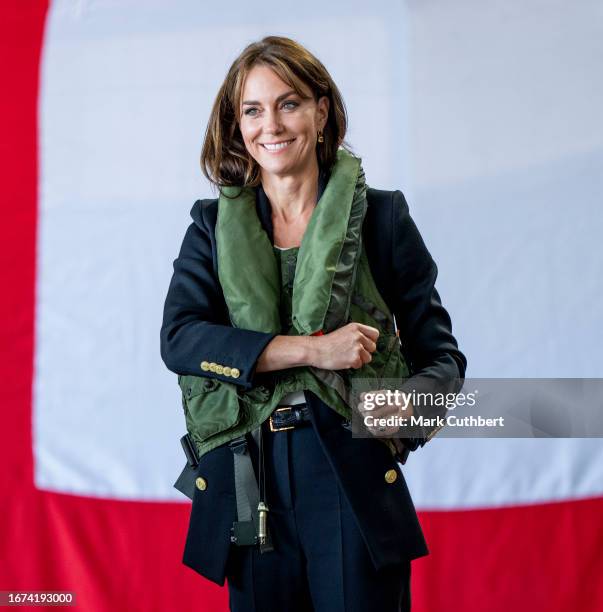 Catherine, Princess Of Wales packs a life vest before setting it off during her visit to Royal Naval Air Station Yeovilton on September 18, 2023 in...