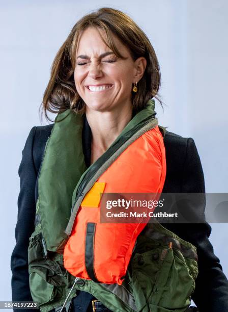 Catherine, Princess Of Wales packs a life vest before setting it off during her visit to Royal Naval Air Station Yeovilton on September 18, 2023 in...